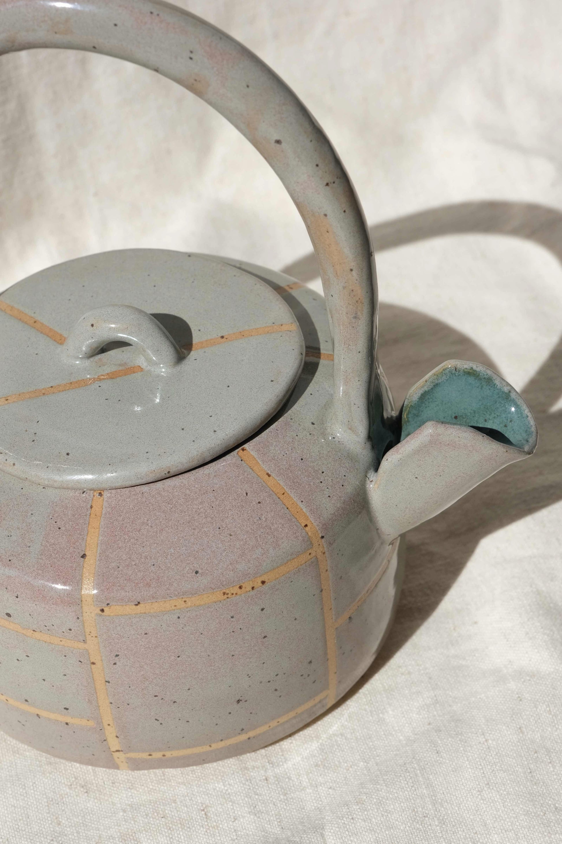 Close-up of the spout and teal green interior of the handmade ceramic teapot